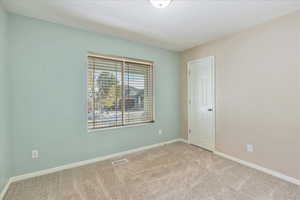 Empty room featuring light colored carpet