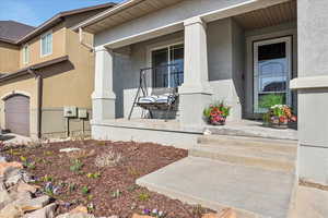 View of exterior entry featuring a porch and stucco siding