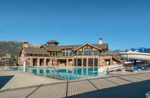 View of pool featuring a mountain view, a patio area, and a water slide