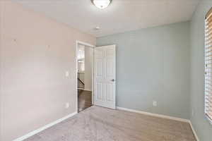 Unfurnished bedroom featuring baseboards and carpet