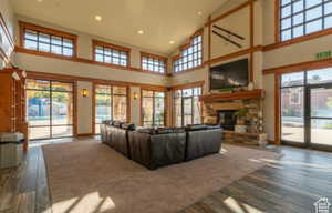 Living room with dark hardwood / wood-style floors, a fireplace, and a high ceiling