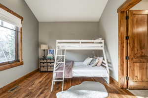 Bedroom with hardwood / wood-style flooring and vaulted ceiling