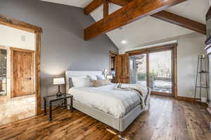 Bedroom with access to outside, hardwood / wood-style floors, high vaulted ceiling, and beam ceiling