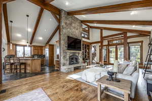 Living room with beam ceiling, french doors, dark wood-type flooring, high vaulted ceiling, and a fireplace