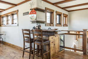 Kitchen with beamed ceiling and hardwood / wood-style flooring