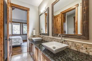 Bathroom with vanity, hardwood / wood-style flooring, and tasteful backsplash