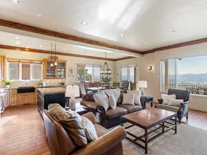 Living room featuring crown molding, light wood-type flooring, sink, and a chandelier