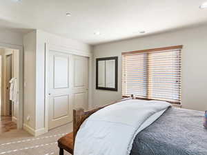 Bedroom featuring light colored carpet and a closet