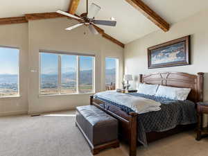 Carpeted bedroom featuring a mountain view, beam ceiling, high vaulted ceiling, and ceiling fan