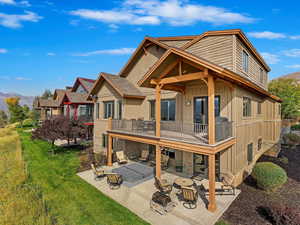 Back of house featuring a lawn, outdoor lounge area, a mountain view, a balcony, and a patio