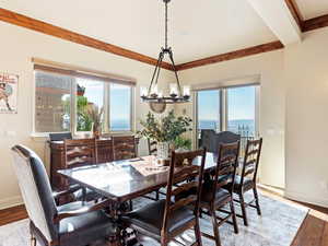 Dining space featuring hardwood / wood-style floors, a water view, and an inviting chandelier