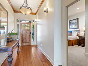 Entrance foyer featuring hardwood / wood-style flooring and crown molding