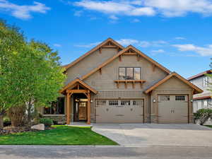 Craftsman-style house featuring a front yard and a garage