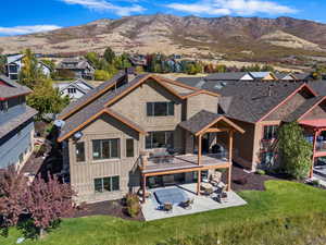 Rear view of house with a lawn, a mountain view, a patio, and an outdoor hangout area