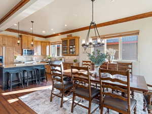 Dining space with crown molding, a chandelier, and dark hardwood / wood-style floors