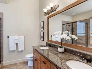 Bathroom with vanity, toilet, and a shower with door