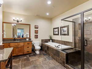 Full bathroom with plus walk in shower, vanity, and toilet