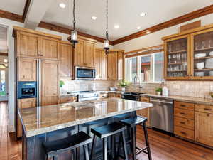 Kitchen with dark hardwood / wood-style floors, a center island, stainless steel appliances, and plenty of natural light