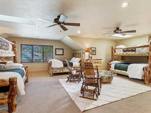 Bedroom featuring ceiling fan, light carpet, and a skylight