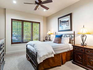 Bedroom with ceiling fan and light carpet