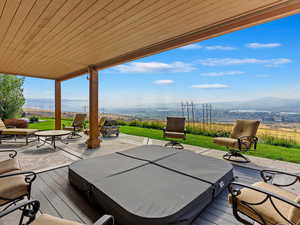 Deck featuring a covered hot tub and a mountain view