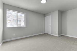 Carpeted spare room featuring a textured ceiling