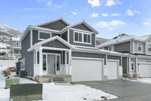 View of front of home featuring a mountain view, central AC, and a garage