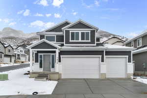 View of front of house featuring a mountain view, a garage, and cooling unit