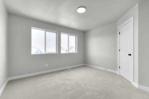 Unfurnished room with a textured ceiling and light carpet