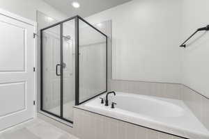 Bathroom with shower with separate bathtub, tile patterned flooring, and a textured ceiling