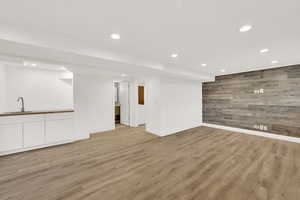 Unfurnished living room with sink and light hardwood / wood-style floors