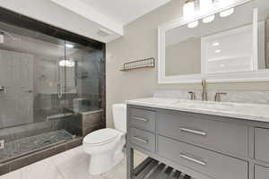 Bathroom featuring vanity, toilet, and a shower with shower door