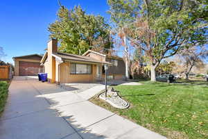 Ranch-style house featuring a garage and a front yard