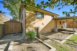 Back of house with a storage shed, central AC, and a patio area