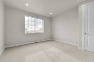 Empty room featuring light colored carpet