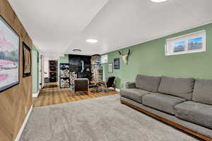 Living room featuring a wood stove, wooden walls, and wood-type flooring