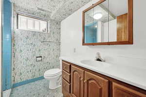 Bathroom featuring tile patterned flooring, vanity, and toilet