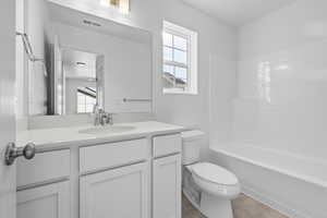 Full bathroom featuring tile patterned flooring, vanity, toilet, and tub / shower combination