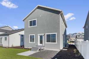 Rear view of house featuring a mountain view, central air condition unit, and a yard