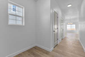 Hall featuring a chandelier, a textured ceiling, and light hardwood / wood-style flooring