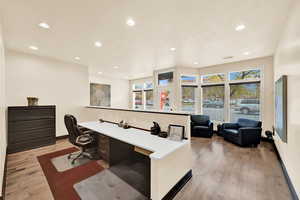 Office with light hardwood / wood-style floors, a healthy amount of sunlight, and built in desk