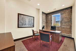 Office area featuring light hardwood / wood-style floors and brick wall