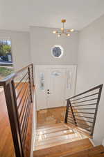 Foyer entrance featuring an inviting chandelier and light hardwood flooring