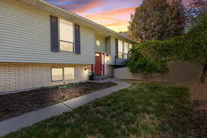 View of front of home featuring brick siding and a front lawn