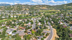 Aerial overview of property's location featuring nearby suburban area and a mountain backdrop