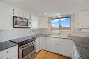 Clean white cabinets, granite counters and subway tile backsplash