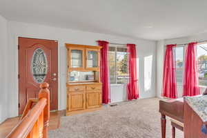 Entrance foyer featuring light carpet