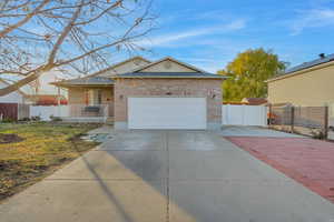 Ranch-style home with a front lawn, covered porch, and a garage