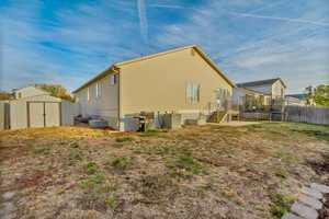 Back of house featuring central air condition unit, a shed, and a trampoline