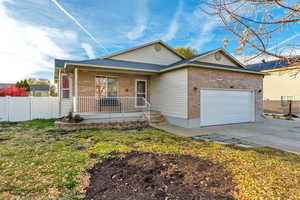 Single story home with covered porch, a garage, and a front yard